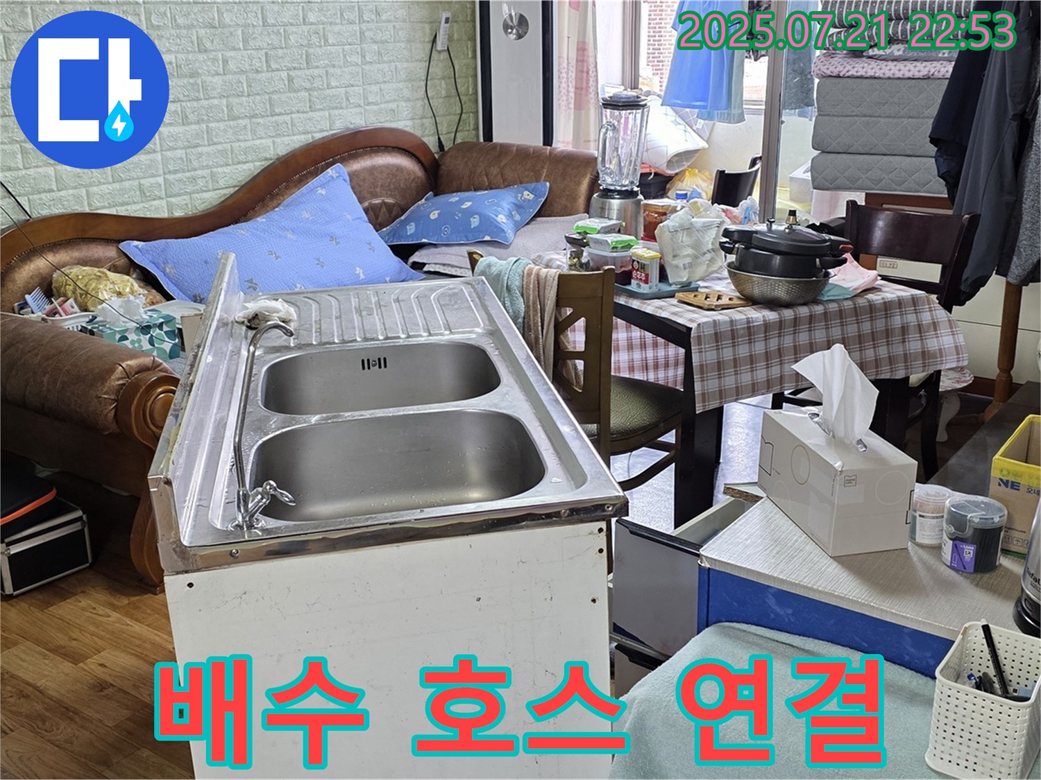 싱크대 주변 정리 후 임시 배수 호스 연결 - 싱크대 주변을 정리하고 임시 배수 호스를 연결하여 물이 잘 빠지도록 했습니다.