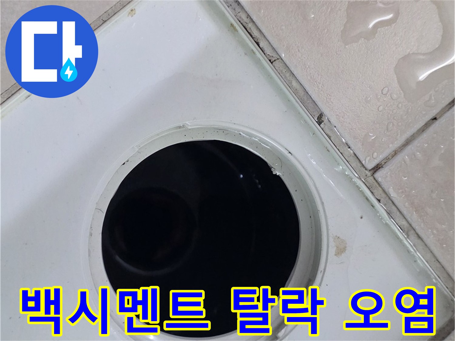화장실 배수구 주변 타일에 물이 맺혀 있는 모습입니다.