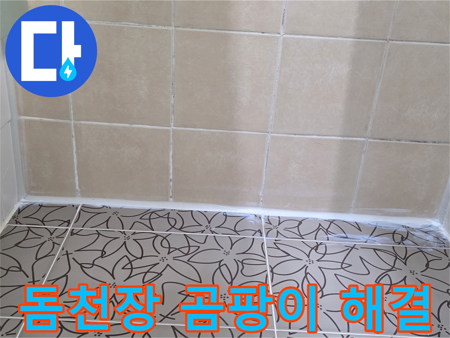 꽃무늬 패턴의 화장실 천장재와 베이지색 욕실 타일 모습