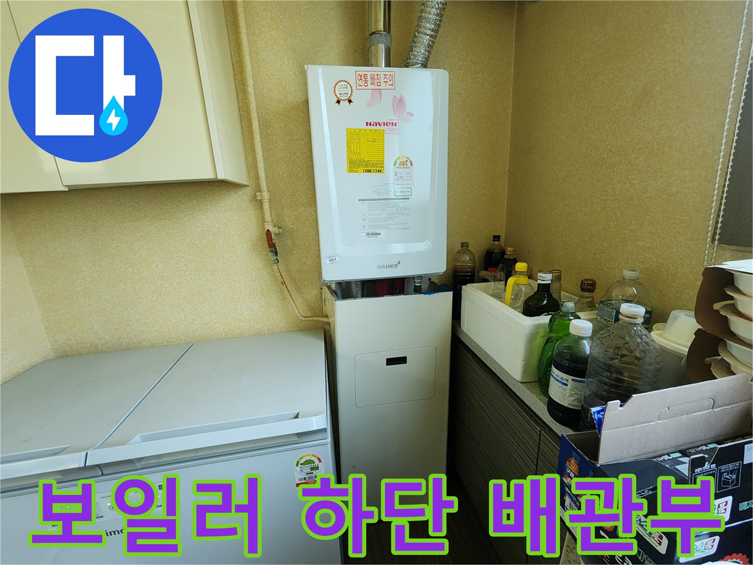 흰색 보일러 아래쪽으로 연결된 금속 및 플라스틱 배관 구조