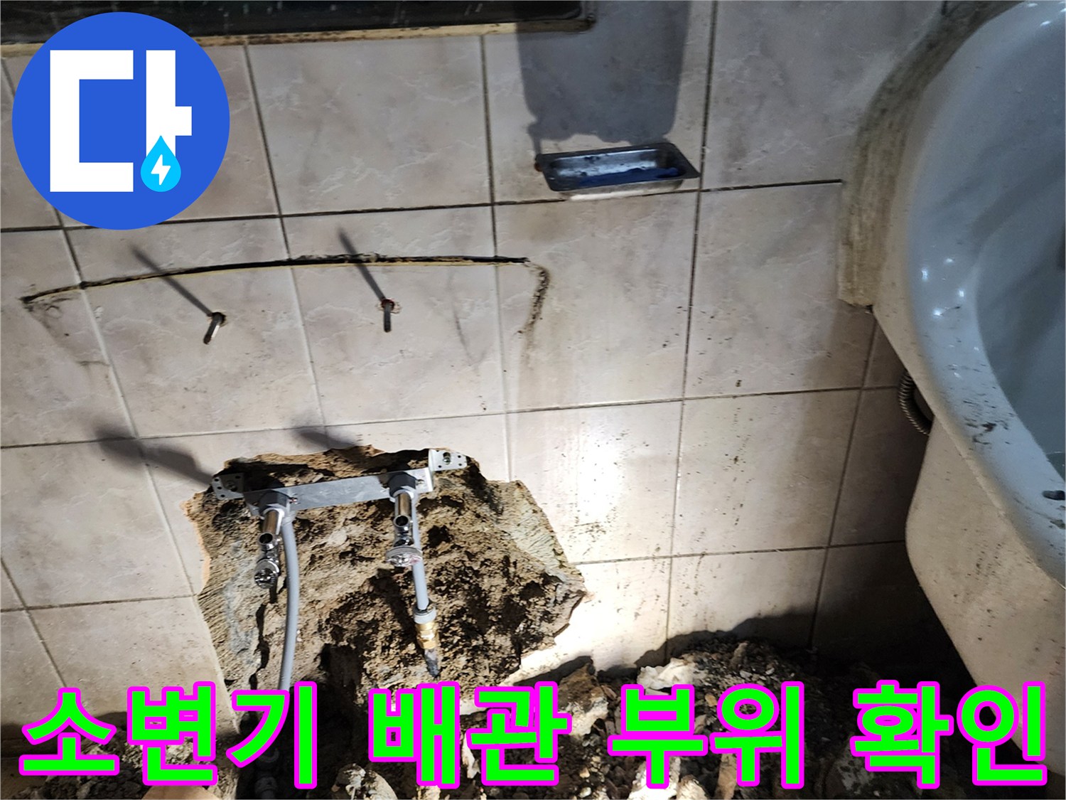 소변기와 세면대 사이 벽면을 굴착하여 노출된 배관 연결부
