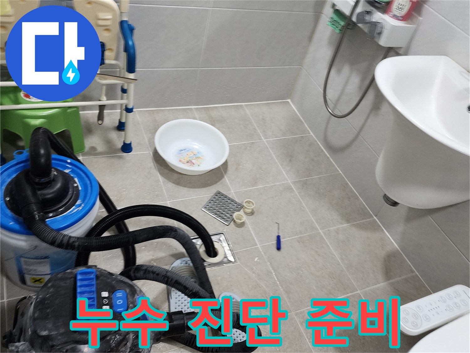 배수구 주변의 누수 지점을 찾기 위해 각종 점검 도구를 배치한 욕실 내부입니다.
