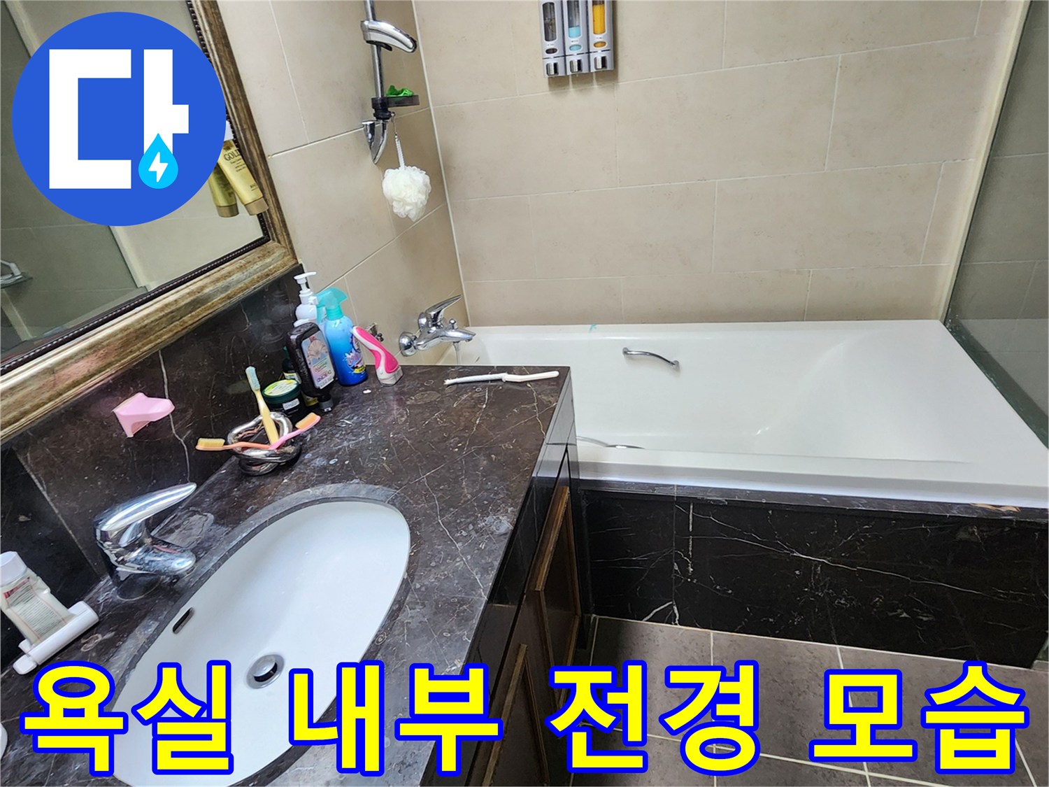 세면대와 수전 및 욕조가 배치된 욕실의 전체적인 모습입니다.
