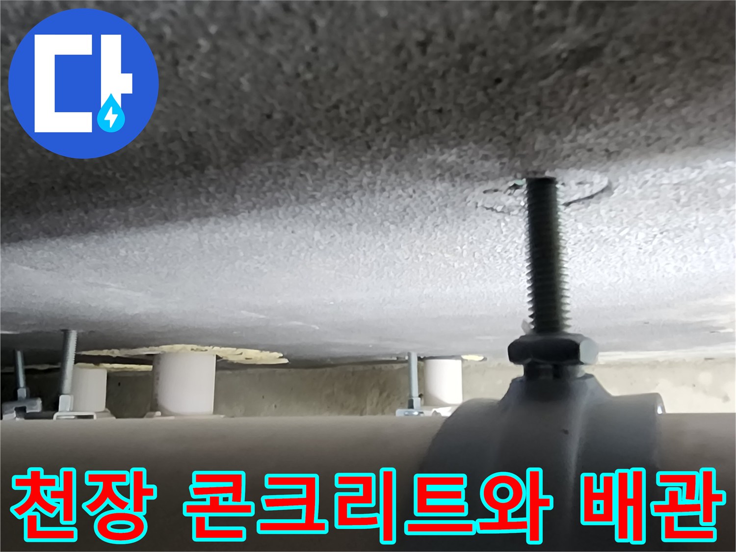 거친 질감의 천장 콘크리트 면과 배관을 고정하는 금속 부품