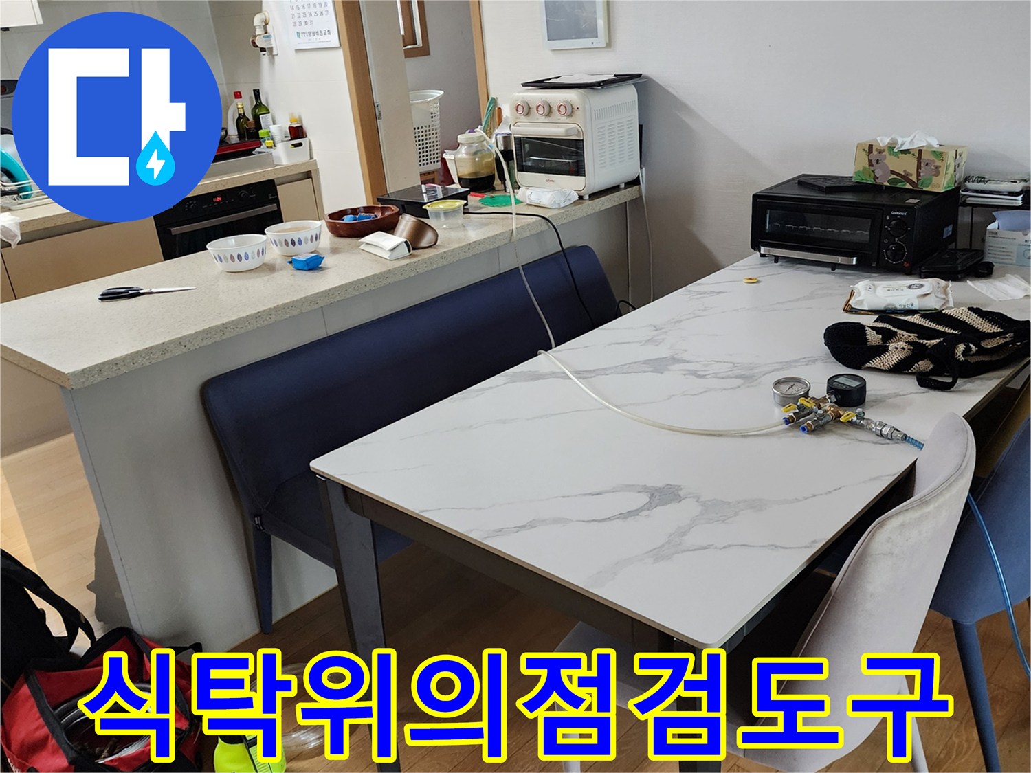 식탁 위에 놓인 누수 점검용 압력 게이지와 작업 장비들