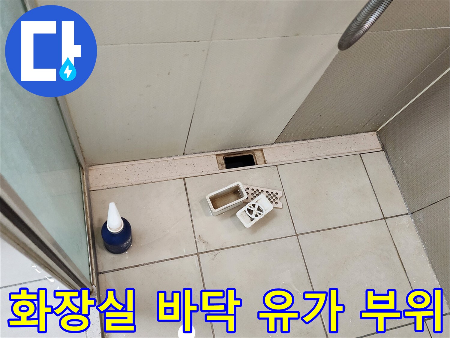화장실 배수구 유가와 주변 타일 마감 상태를 촬영한 사진