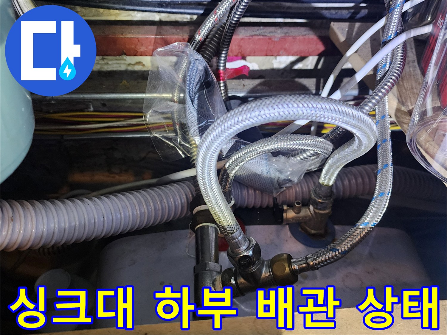 양주시 마전동-싱크대 하부장 내부의 금속 재질 유연 호스와 배관 연결 부위 사진입니다.