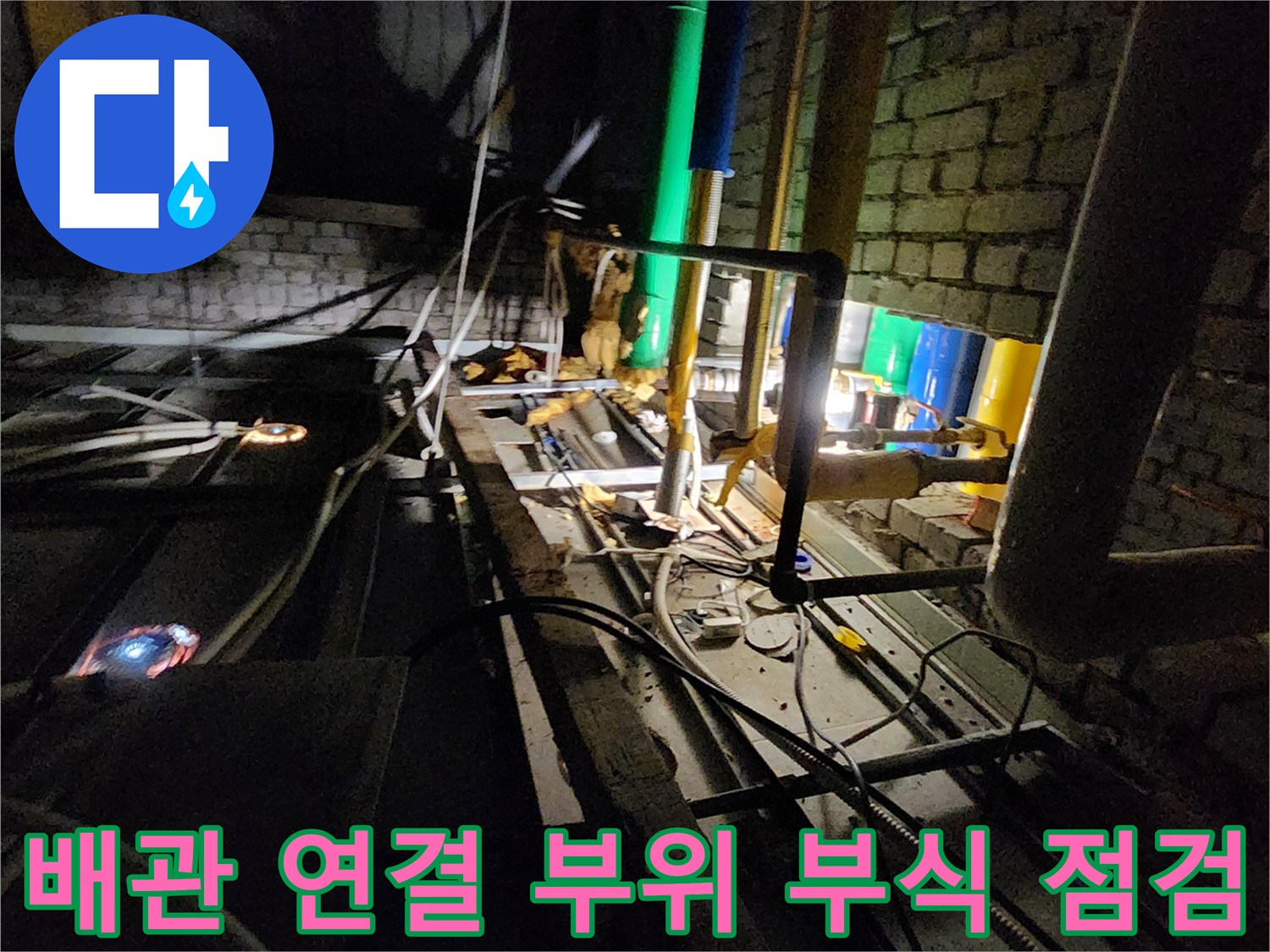 벽돌 구조물 사이의 노후된 금속 배관 및 밸브 상세 모습