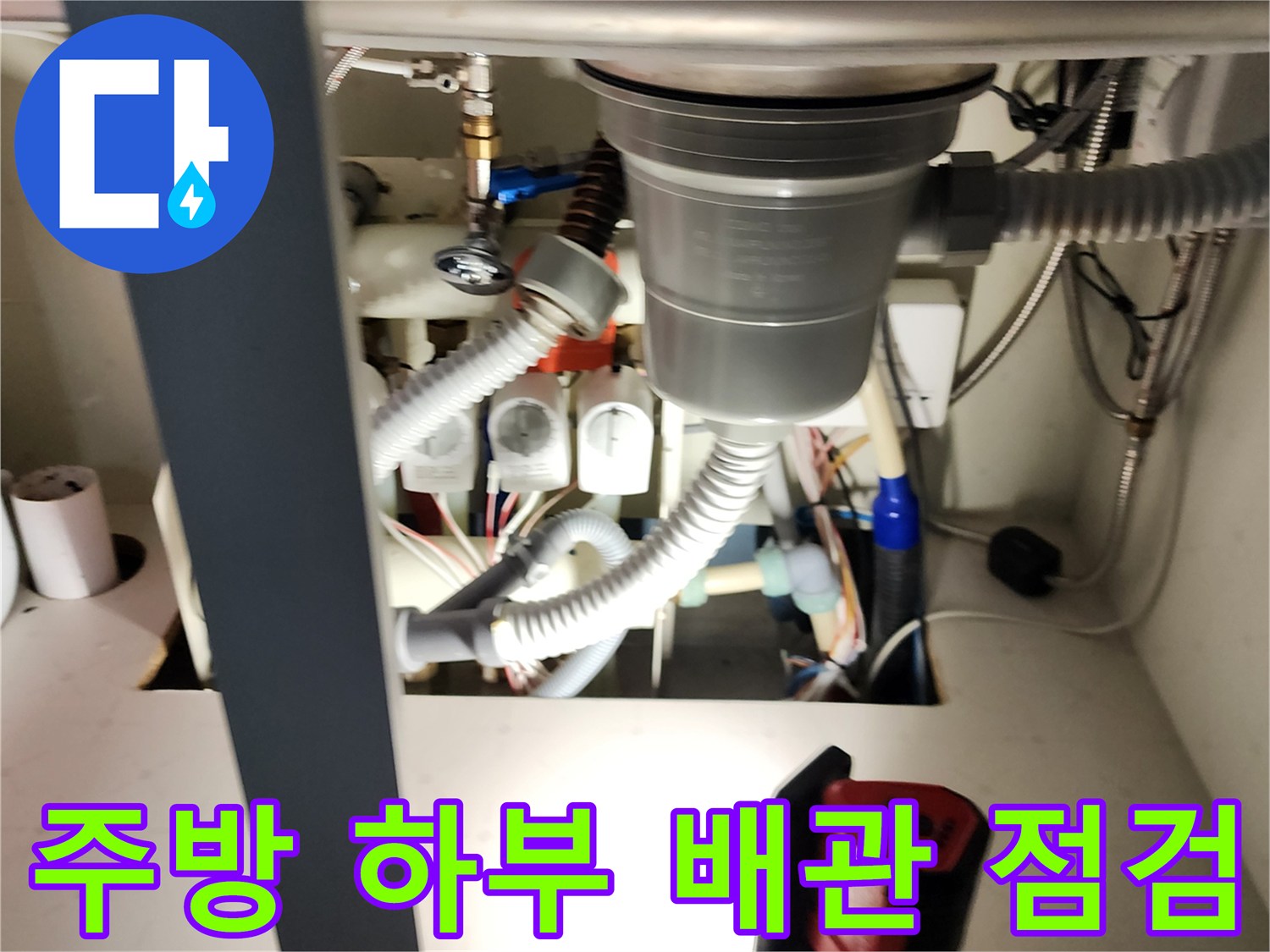 싱크대 하단 배수 호스와 밸브 부속들이 모여 있는 배관 구조물 사진
