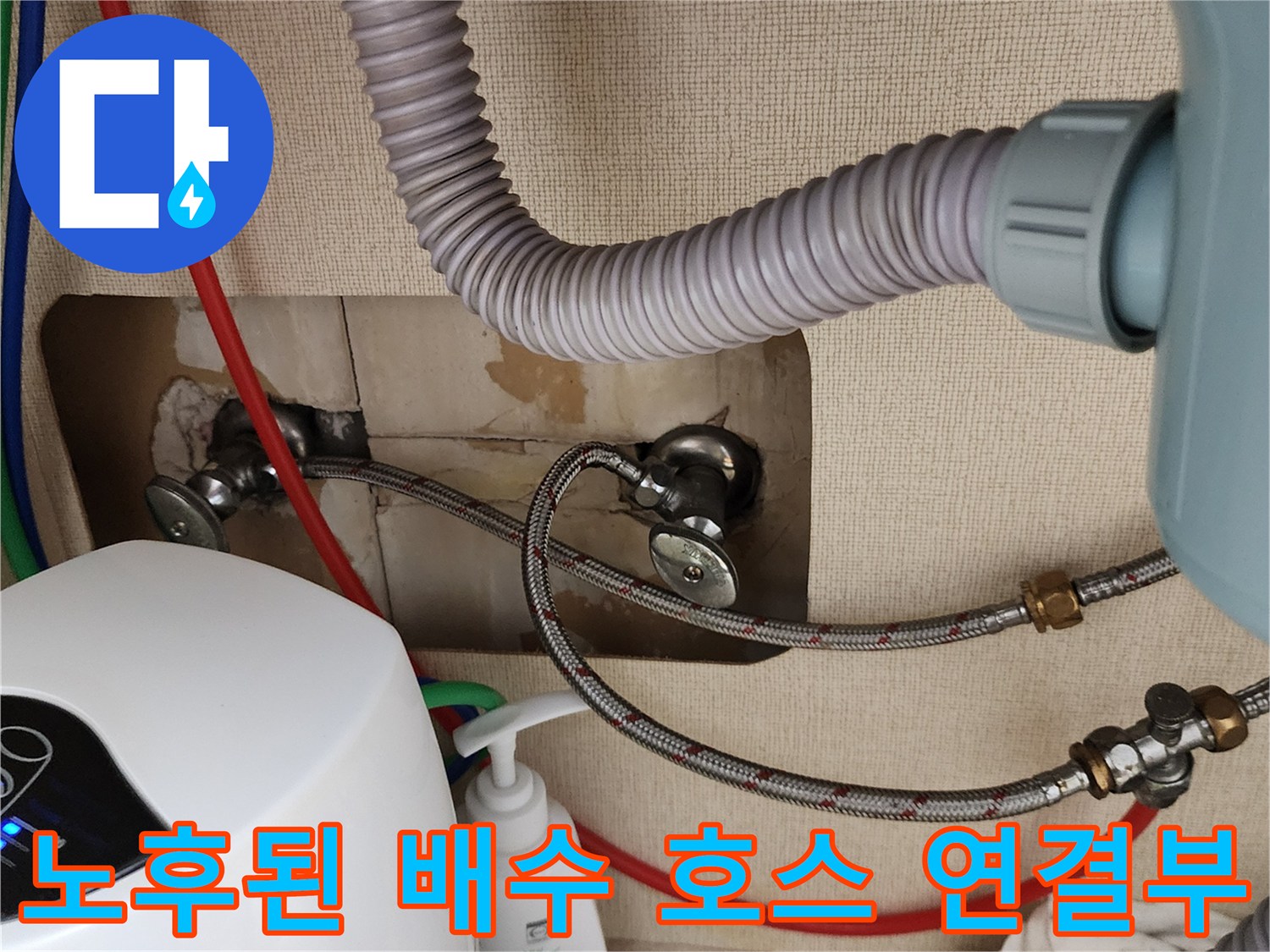 회색 주름관과 금속 재질의 급수 배관이 만나는 지점의 상세 사진입니다.