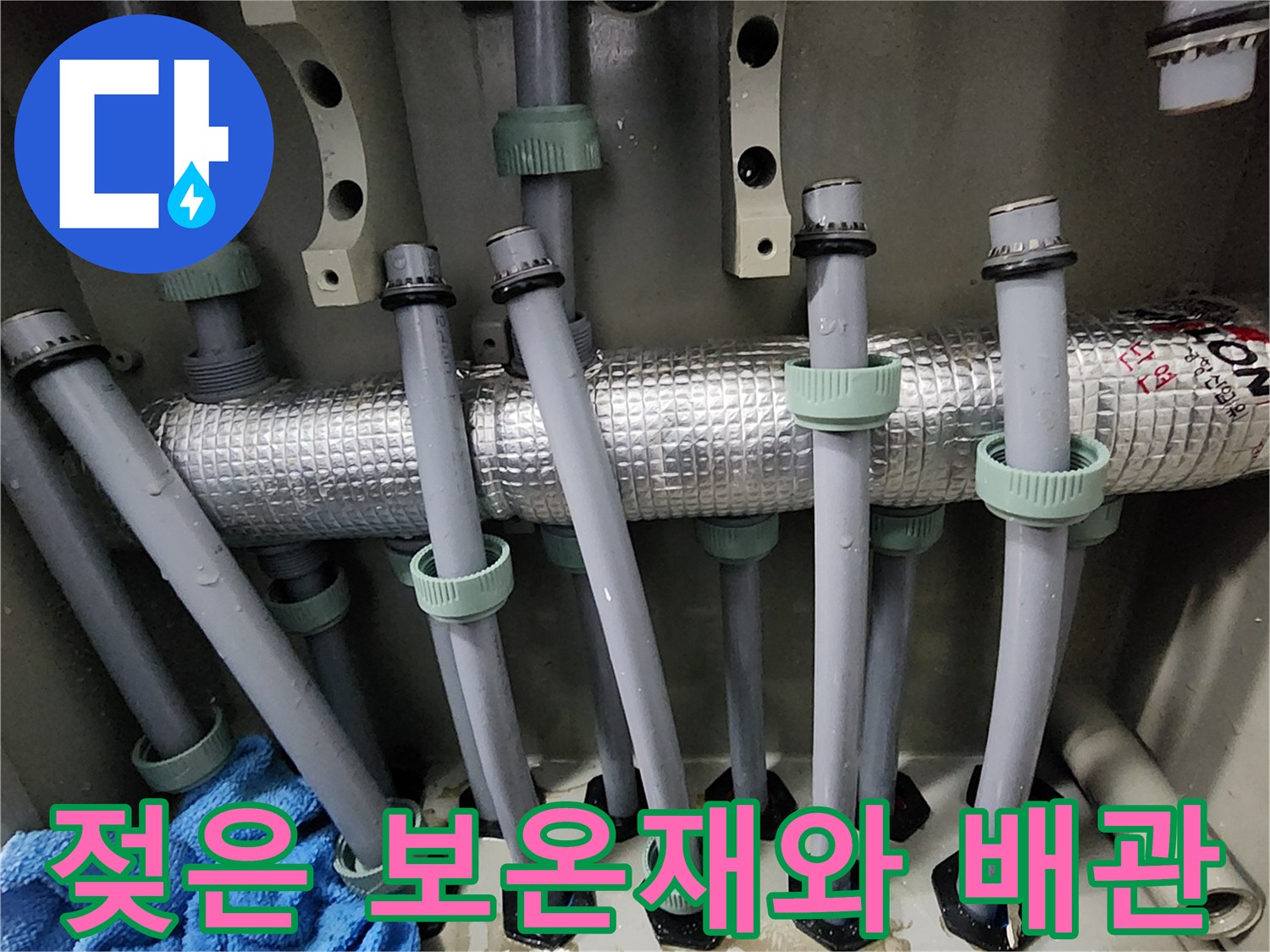 물기가 맺힌 은색 보온재와 아래로 뻗어 나가는 분배기 배관들