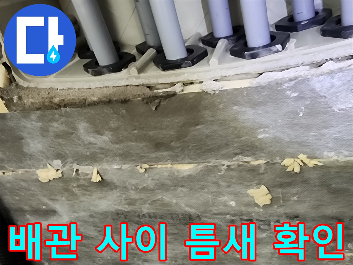 매립된 배관 주변의 마감재와 벌어진 틈을 근접 촬영한 사진입니다.