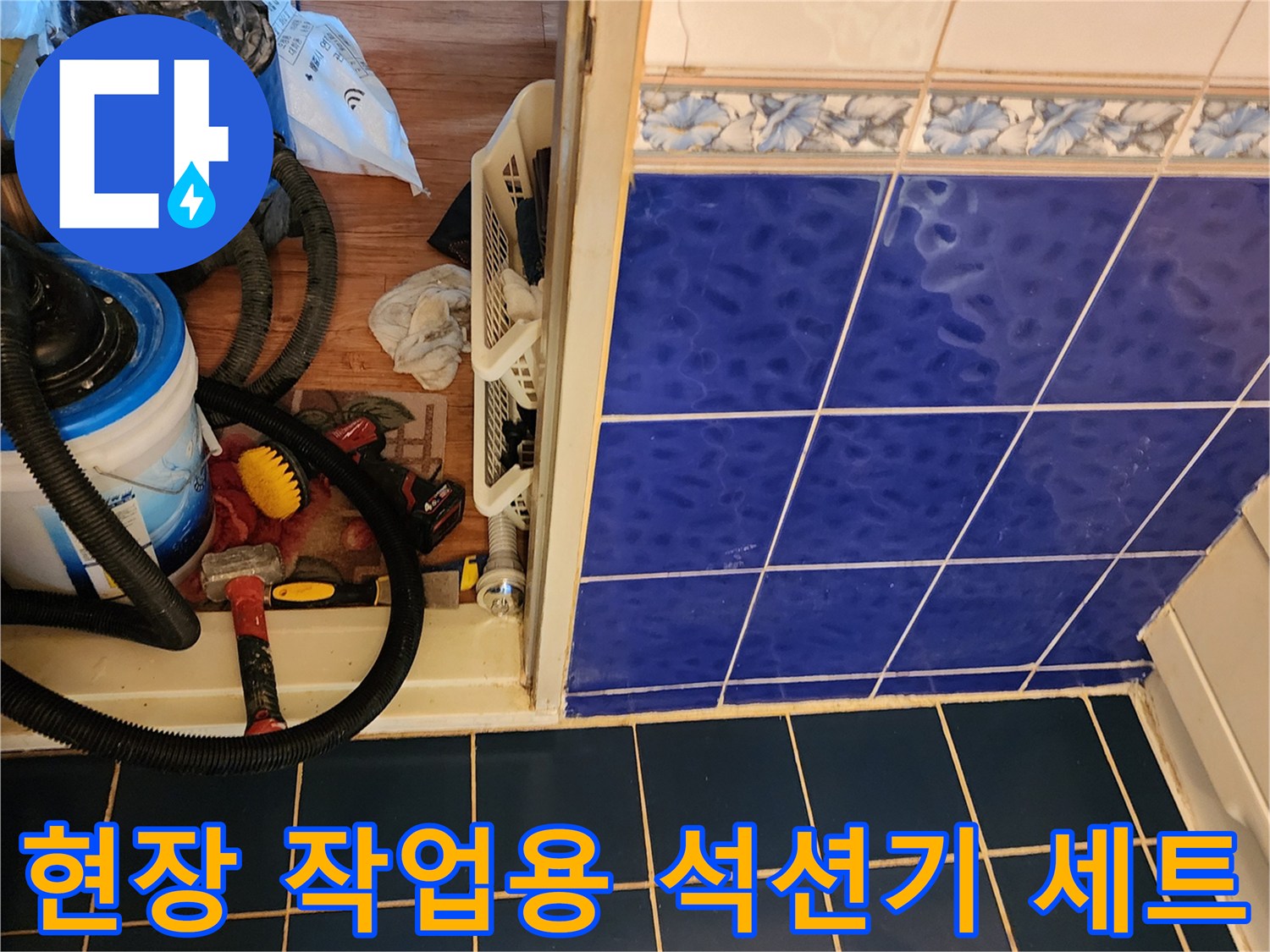욕실 바닥 타일 경계면에-놓여 있는 배관 청소 장비와 석션 호스