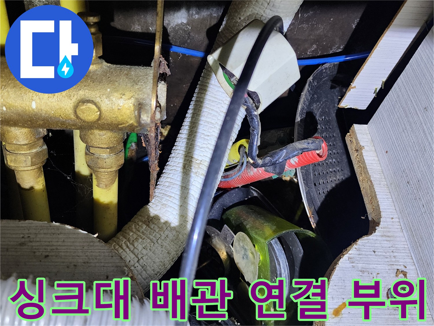 싱크대 하부의 금속 급수관과 흰색 주름관이 만나는 지점