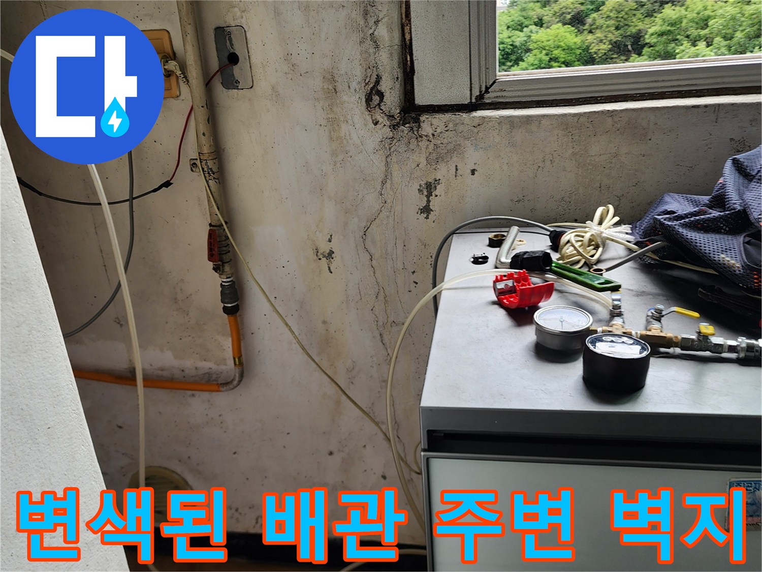 배관 연결 부위 근처의 젖은 벽지와 얼룩