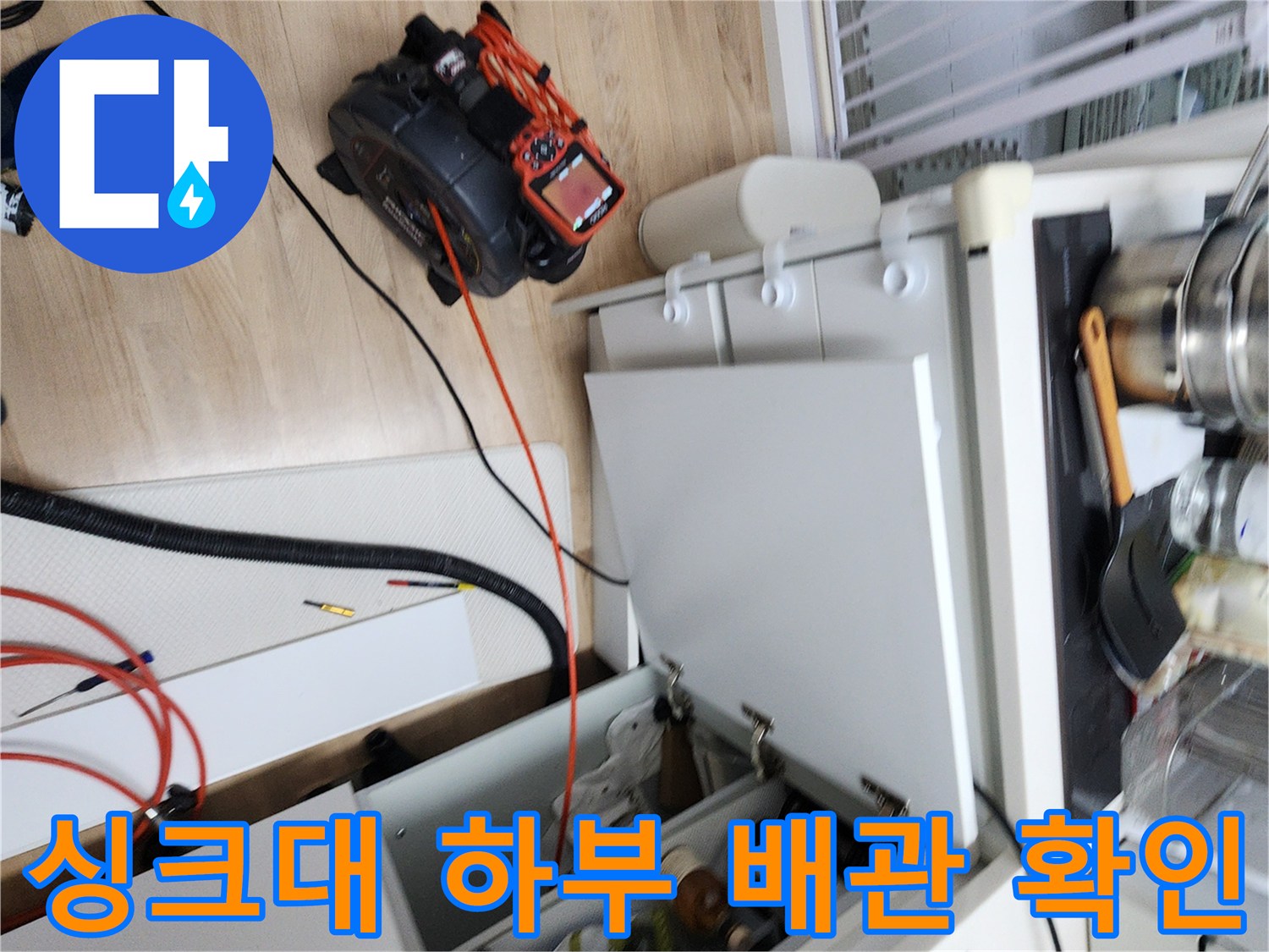 싱크대 아래쪽 공간에 배치된 내시경 장비와 작업 도구입니다.