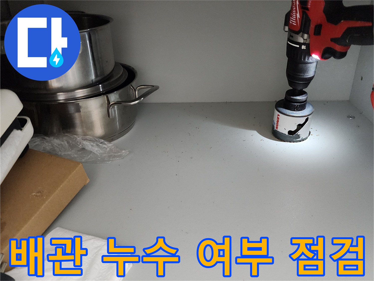 싱크대 하부장 내부의 밝은 빛과 작업용 장비가 보이는 모습