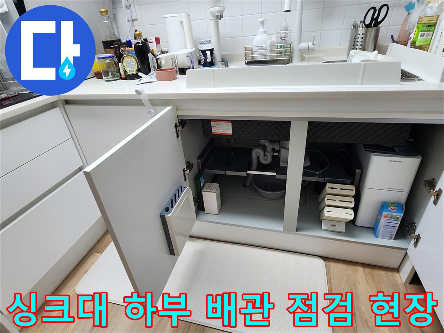 주방 싱크대 아래쪽 배수 호스와 분배기 부근의 내부 모습