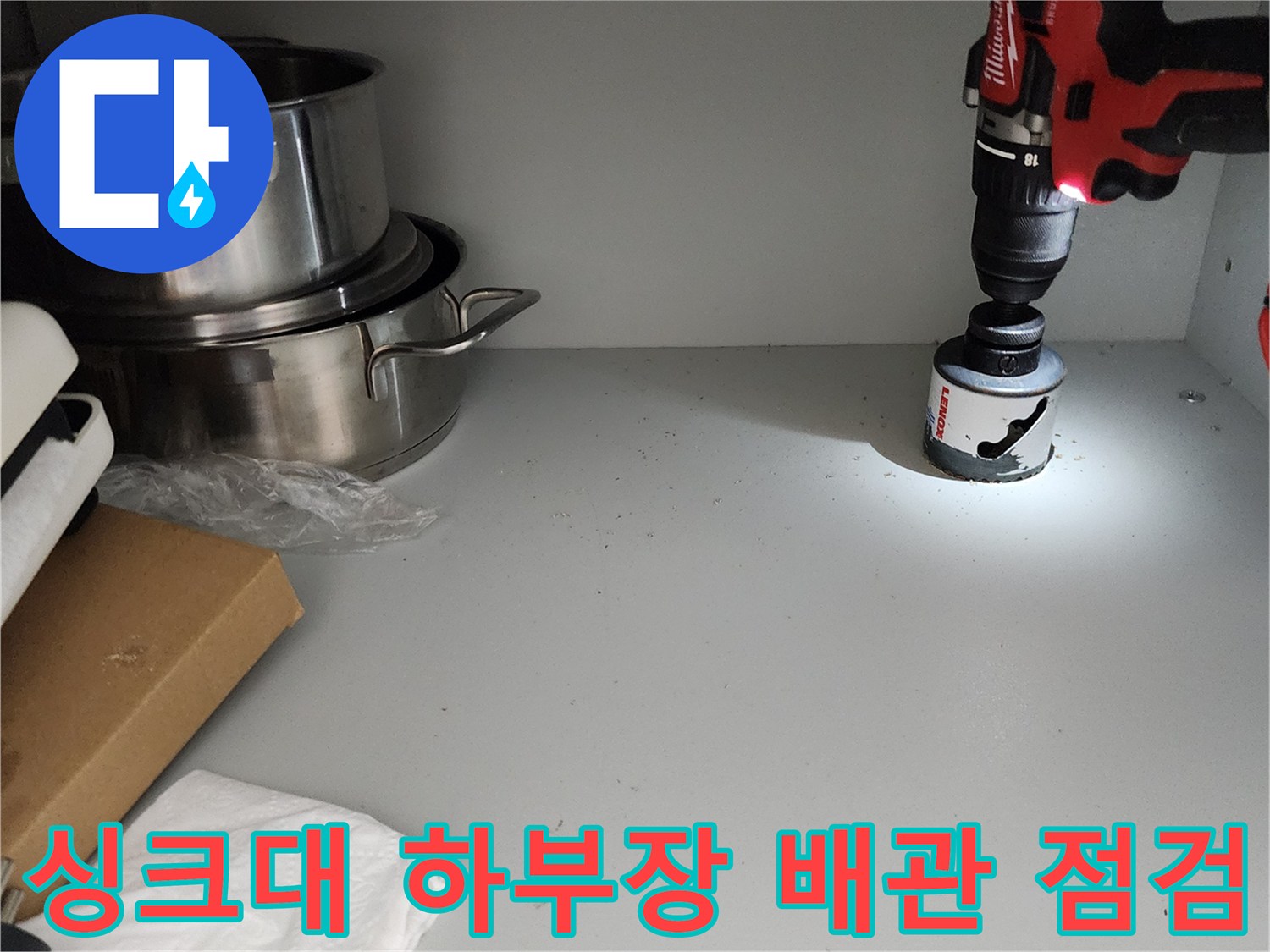 주방 싱크대 하단 선반 위 전동 드릴과 홀쏘 장비 모습