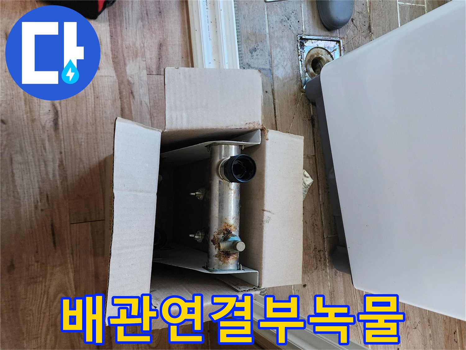 싱크대 아래 박스 안의 부식된 금속 연결 부위 촬영
