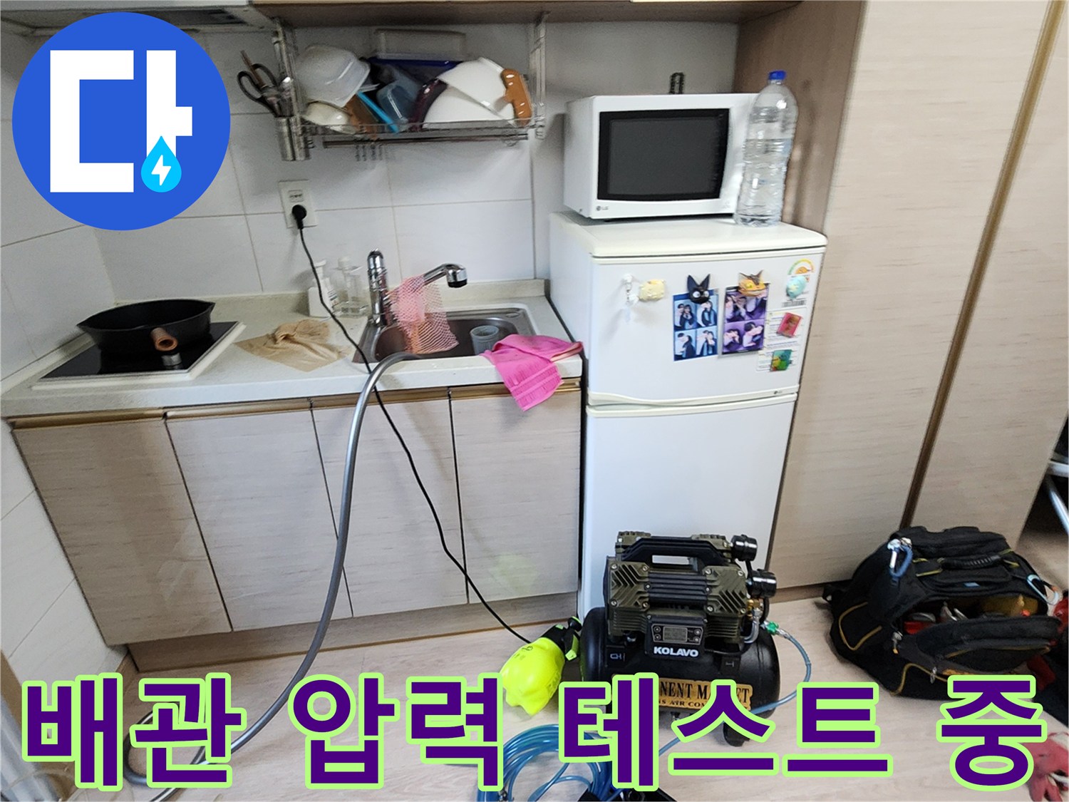싱크대 아래쪽 바닥에 설치된 콤프업레샤와 누수 진단용 호스 연결 상태