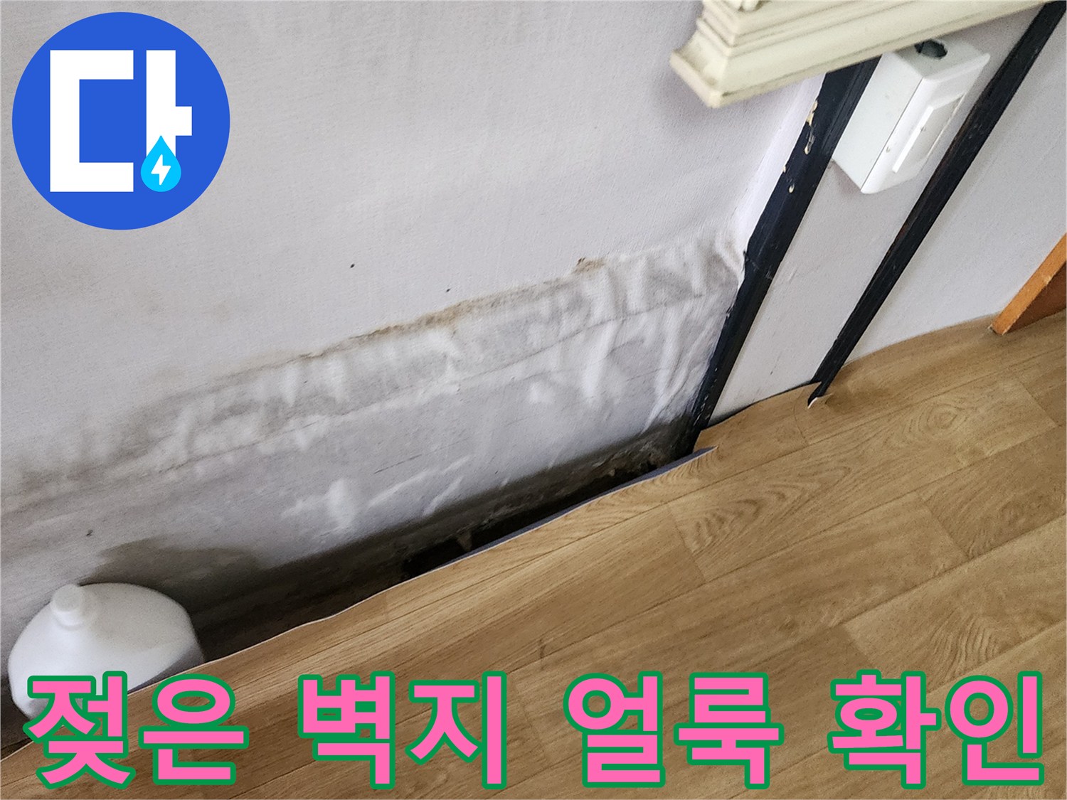 아파트 내부 - 벽지 하단에 나타난 짙은 물 얼룩과 습기 현상
