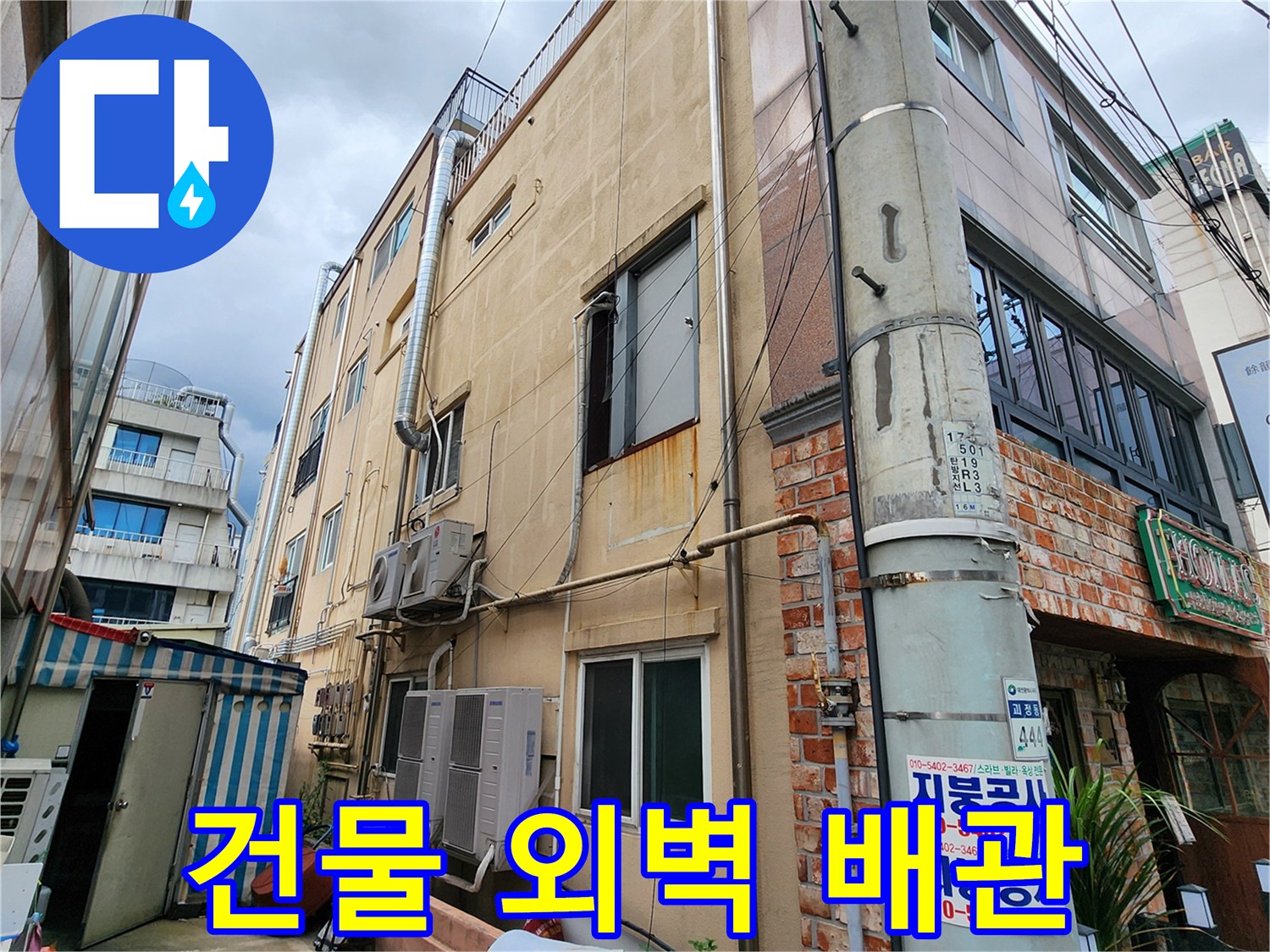 외벽에 설치된 배관과 벽면의 노후 상태를 보여주는 사진입니다.