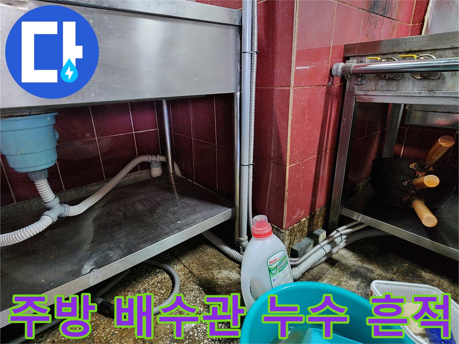 싱크대 하부 작업대 아래 젖어있는 바닥과 배수 호스 모습