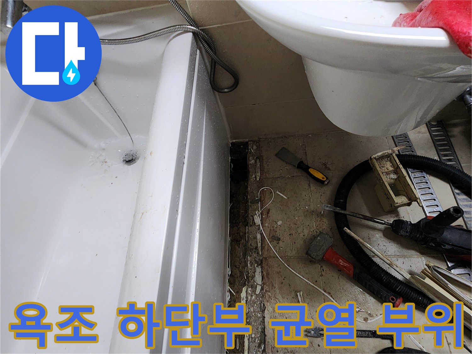 욕조 아래쪽 타일의 갈라짐과 배관 주변을 촬영한 사진입니다.