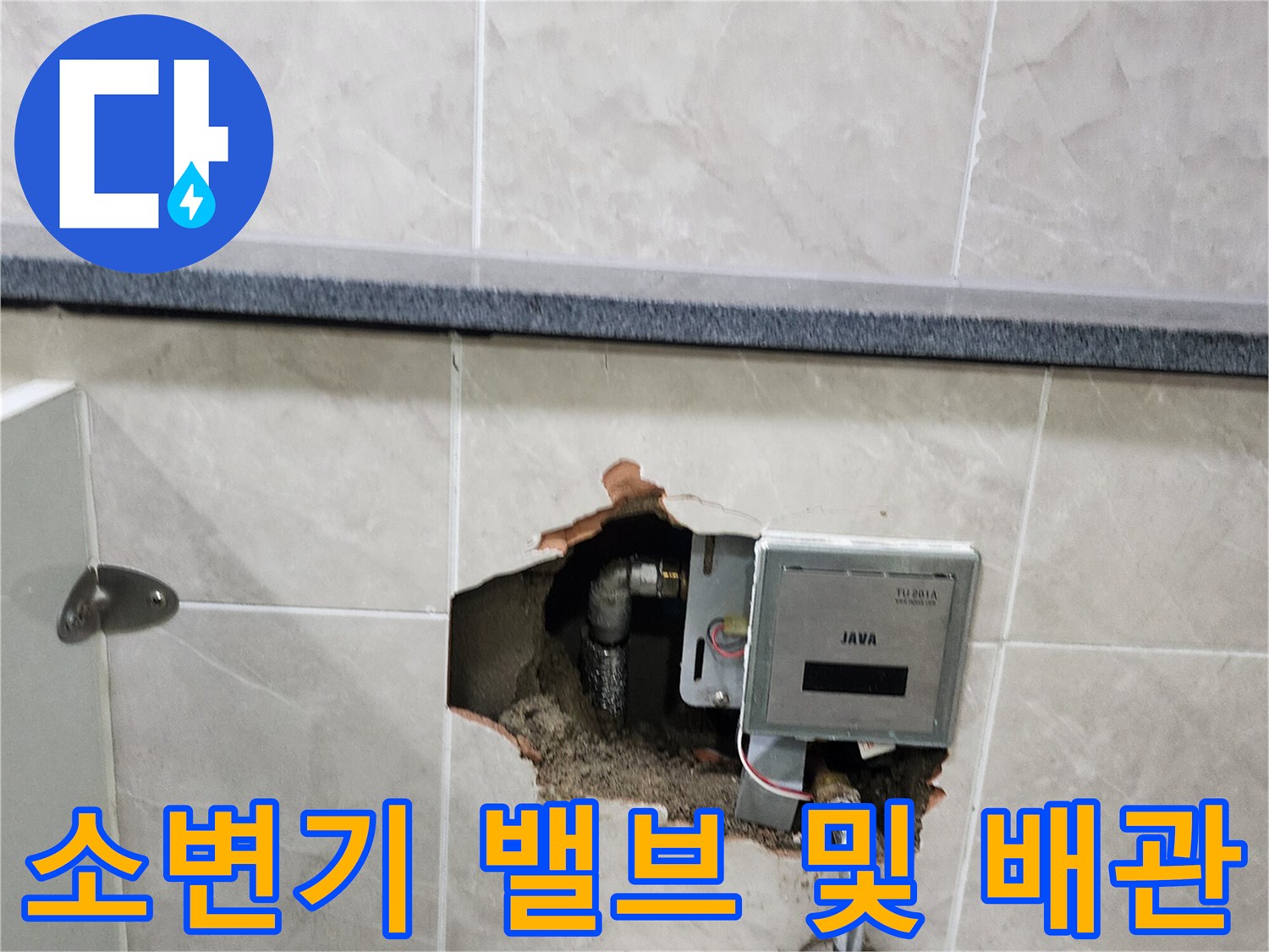 타일 벽면을 제거하여 드러난 소변기 자동 밸브와 금속 급수 배관의 모습입니다.