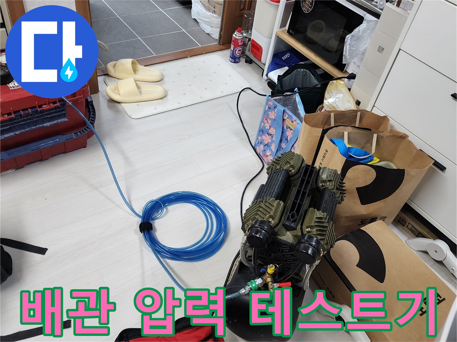 누수 지점을 찾기 위해 사용 중인 공압 테스트 장비와 파란색 호스