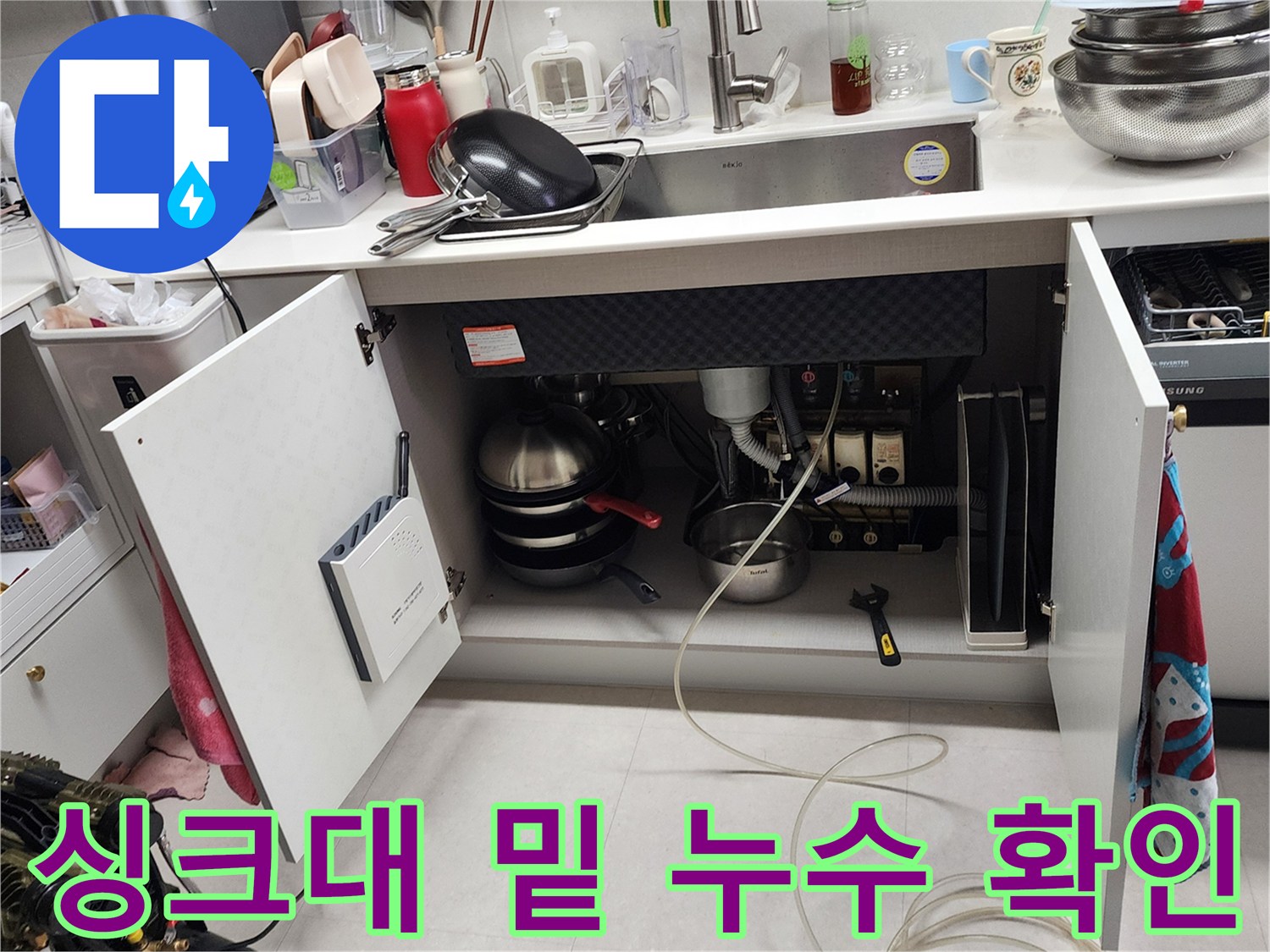 싱크대 아래쪽 배수 파이프와 연결 부위의 결함 여부 확인 중