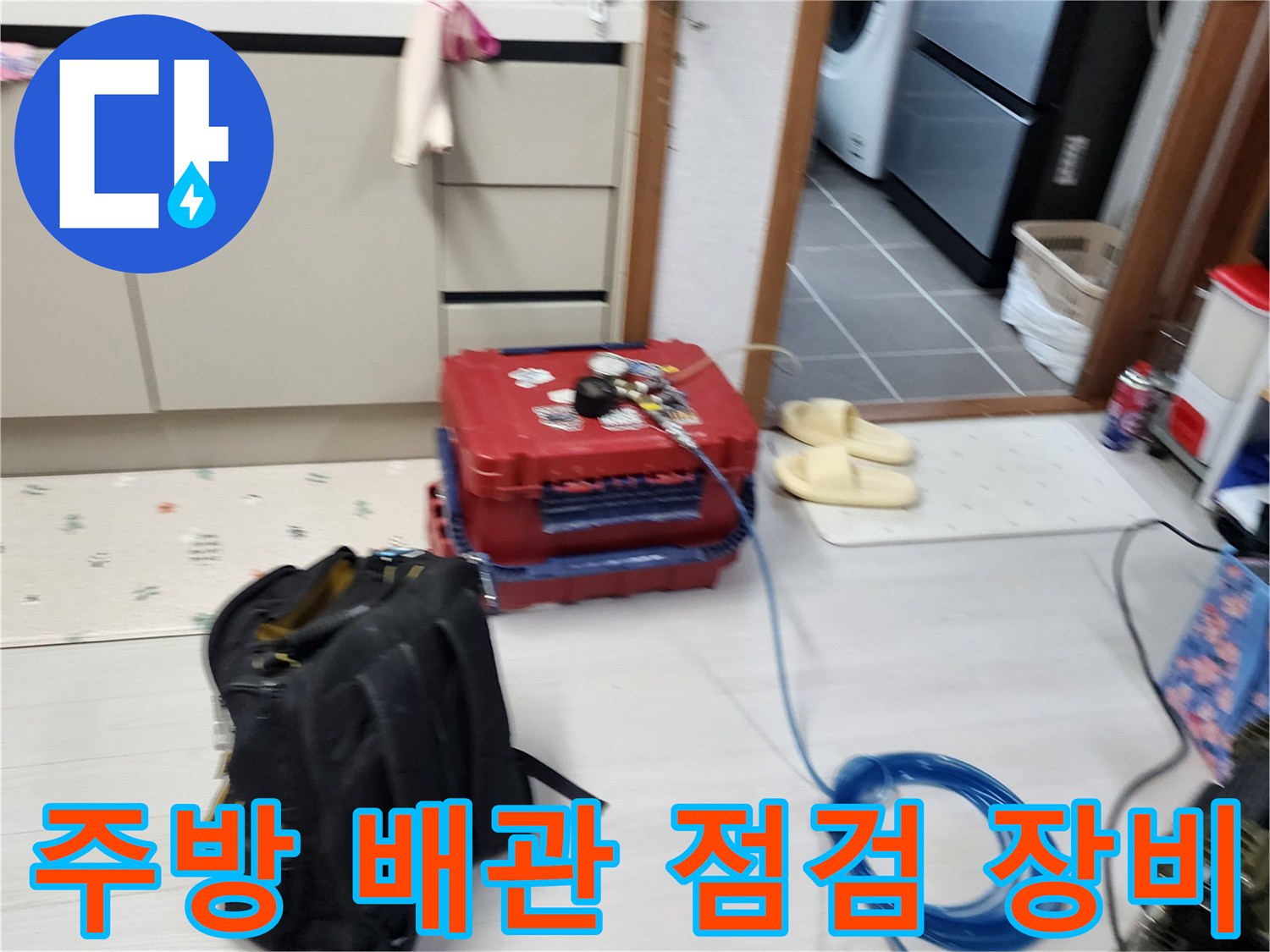 주방 바닥에 배치된 공압 테스트용 장비와 파란색 호스