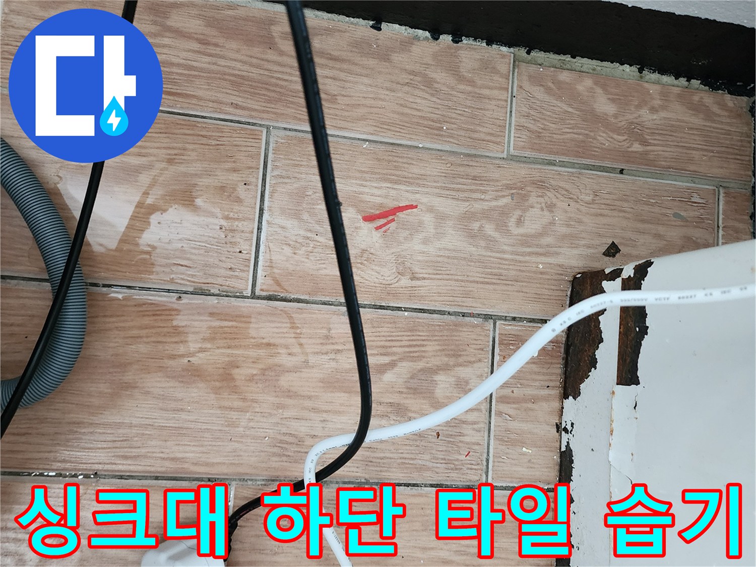 주방 싱크대 아래-젖어 있는 타일 표면과 전선