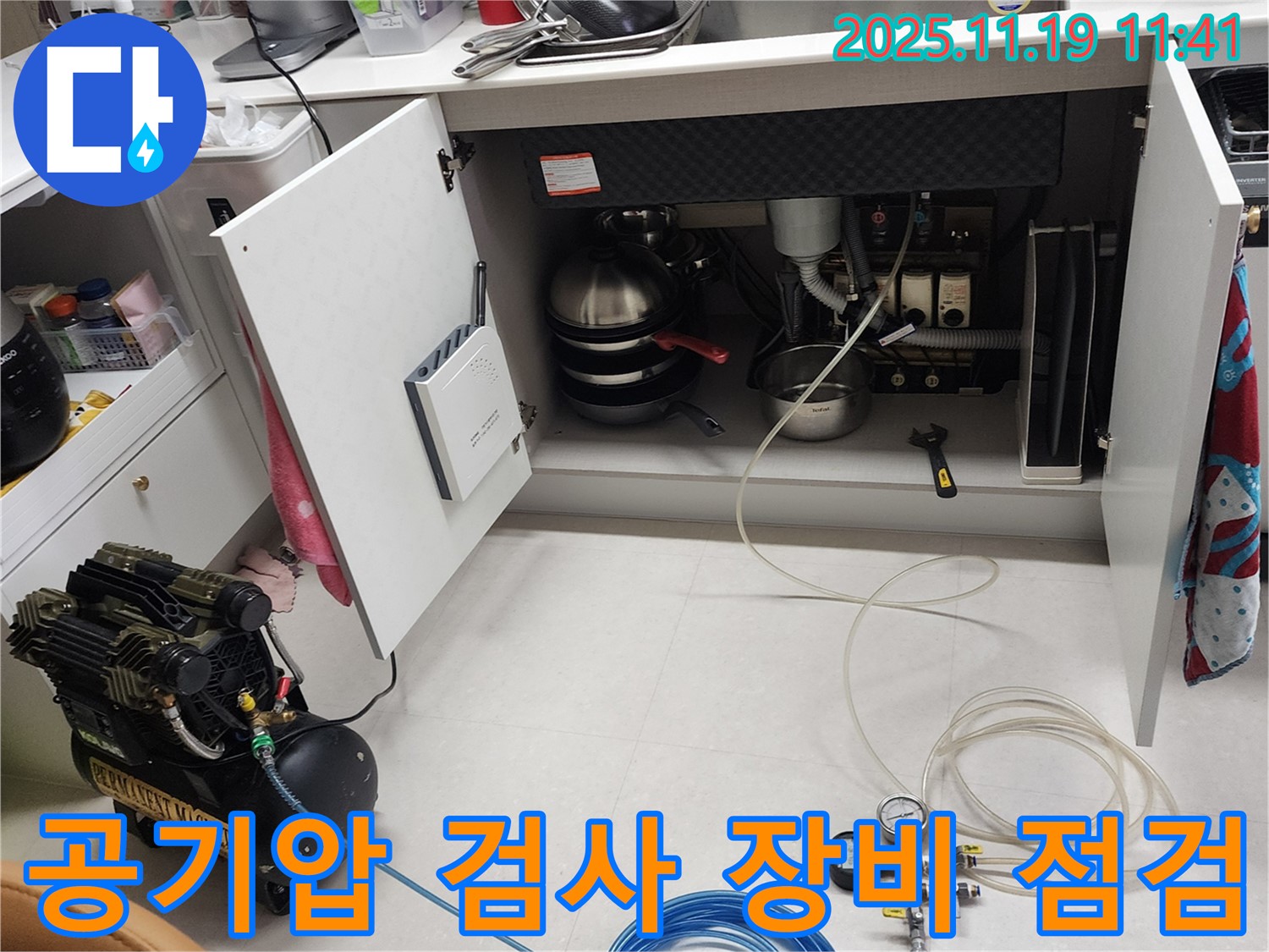 포천 내촌면 마명리 누수 현장 - 싱크대 하부에서 공기압 검사를 위해 사용되는 장비들을 꼼꼼하게 점검하는 모습입니다.