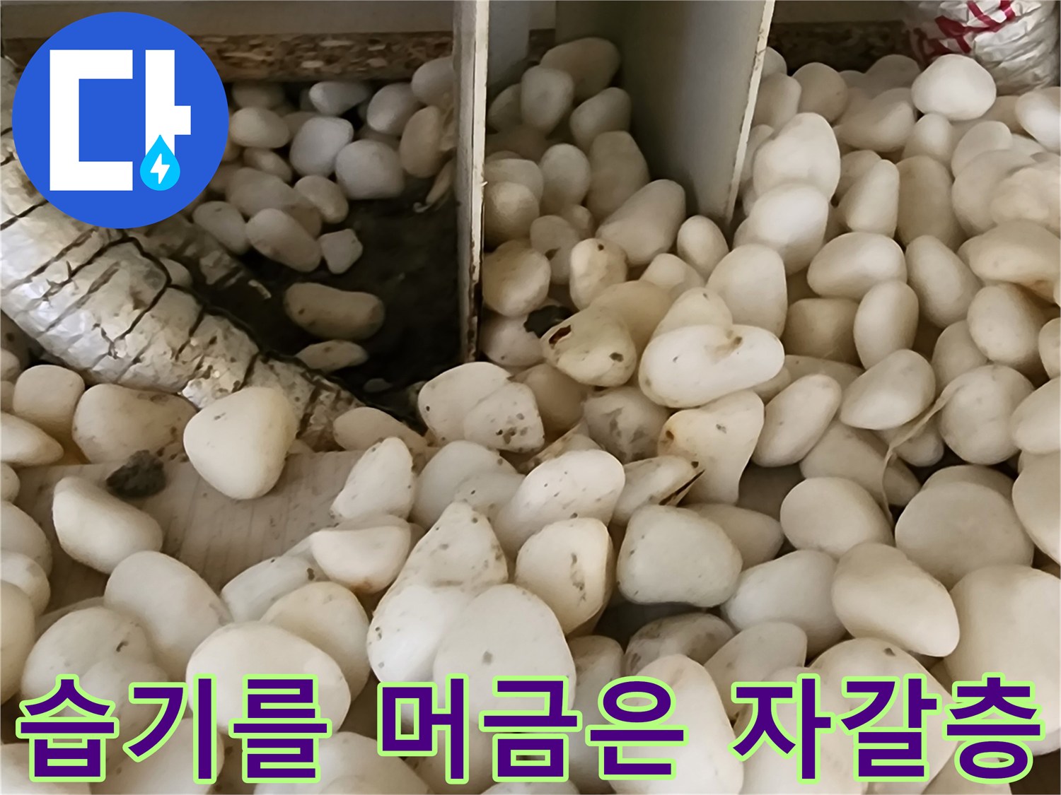 배관 보온재 주변의 젖은 자갈과 배관 부위