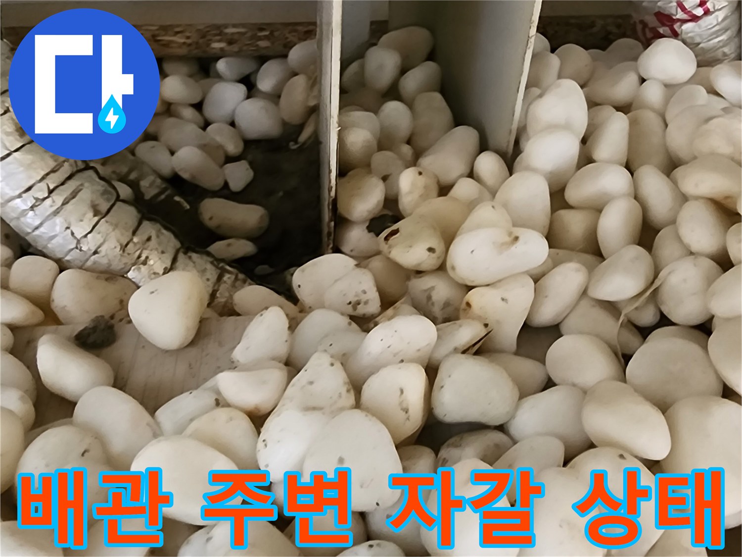 보온재로 감싸진 배관과 젖은 자갈층의 모습