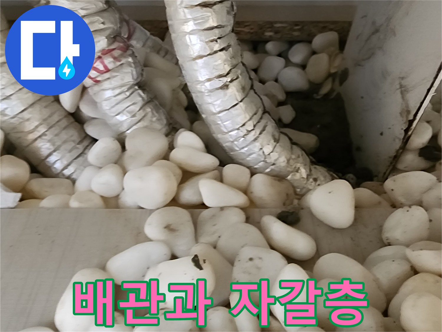 보온재로 감싸진 배납 주변의 자갈층 상태를 보여주는 사진입니다.