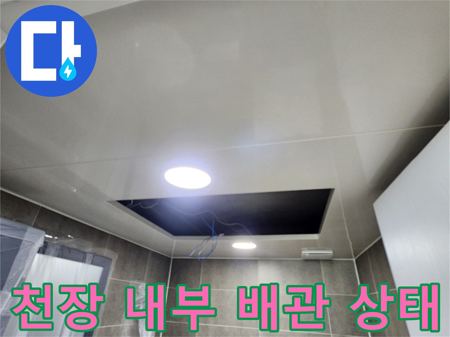 점검구 내부의 어두운 공간과 노출된 배관 라인입니다.