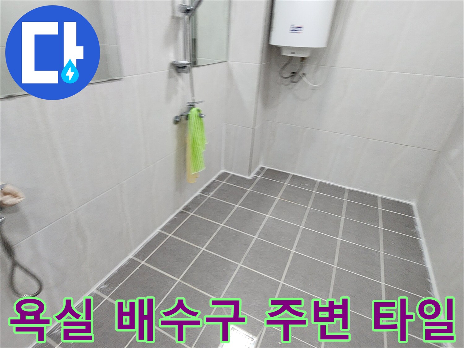 회색 욕실 바닥재와 금속 재질의 배수구 덮개 사진입니다.