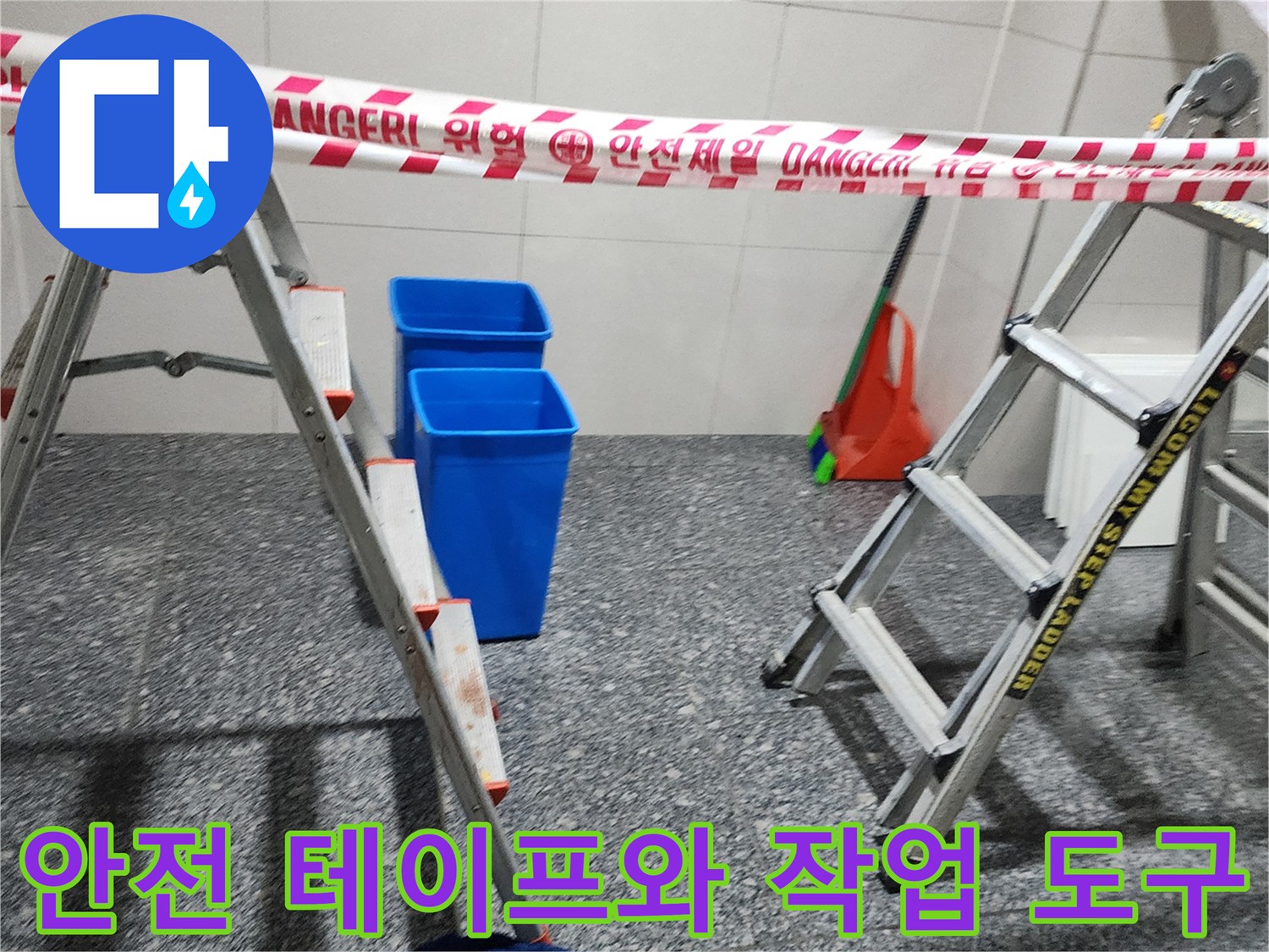 누수 공사 현장에 설치된 위험 구역 표시 테이프와 파란색 양동이