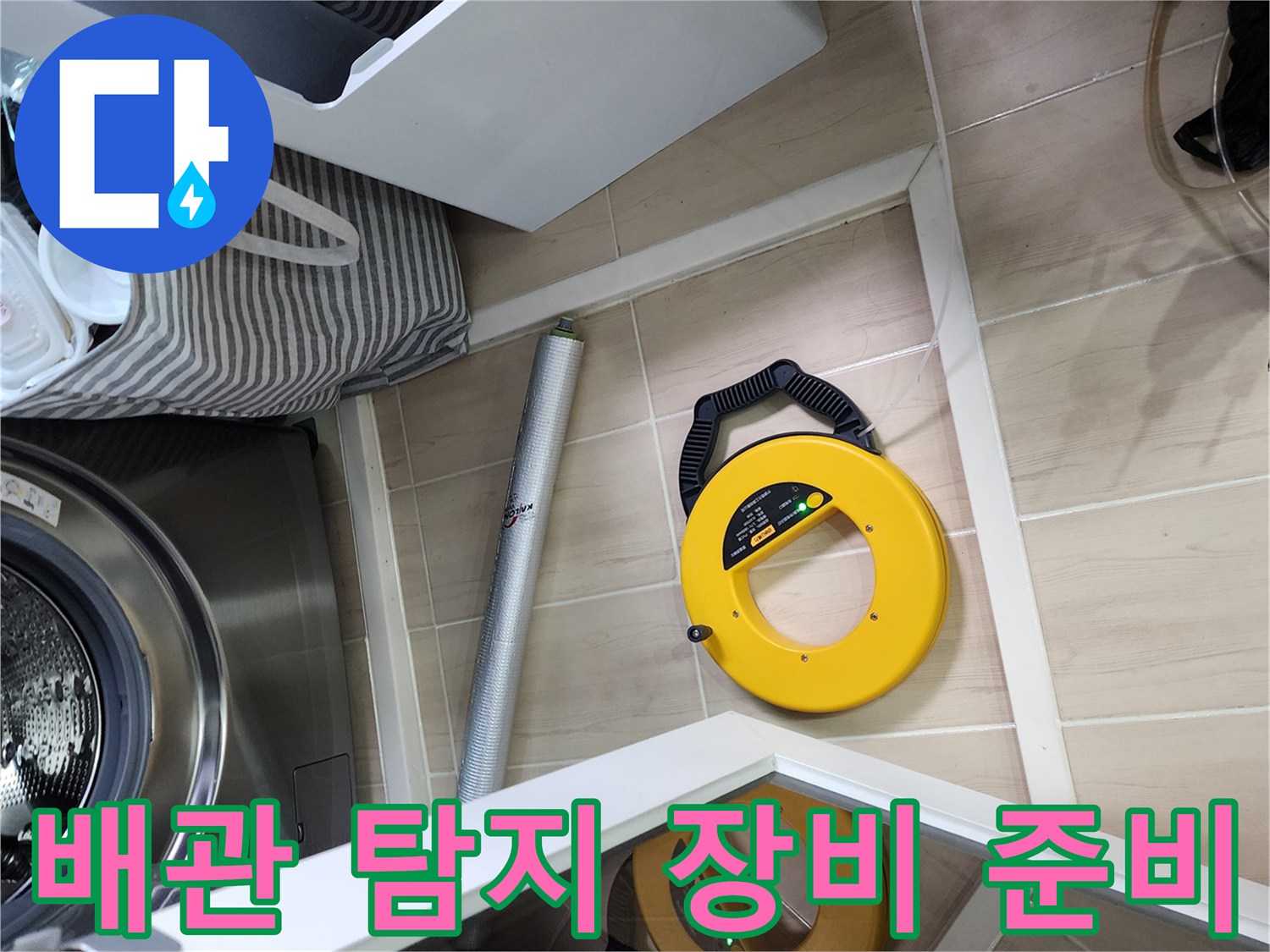 세탁기 옆 바닥에 배치된 노란색 가스식 및 청음식 탐지 도구