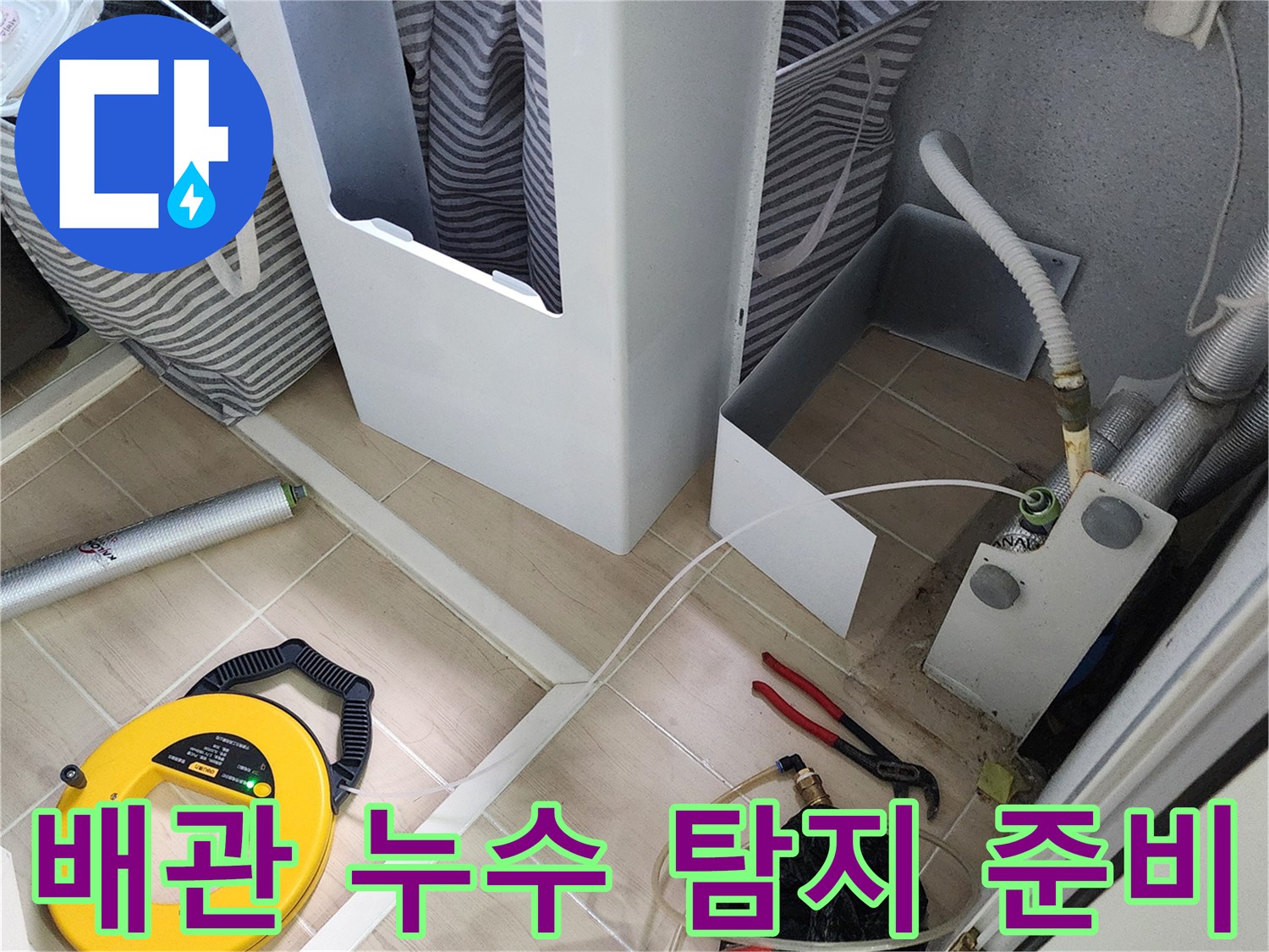 싱크대 하부 배관의 누수를 찾기 위해 바닥에 배치된 가스 탐지 릴과 공구들