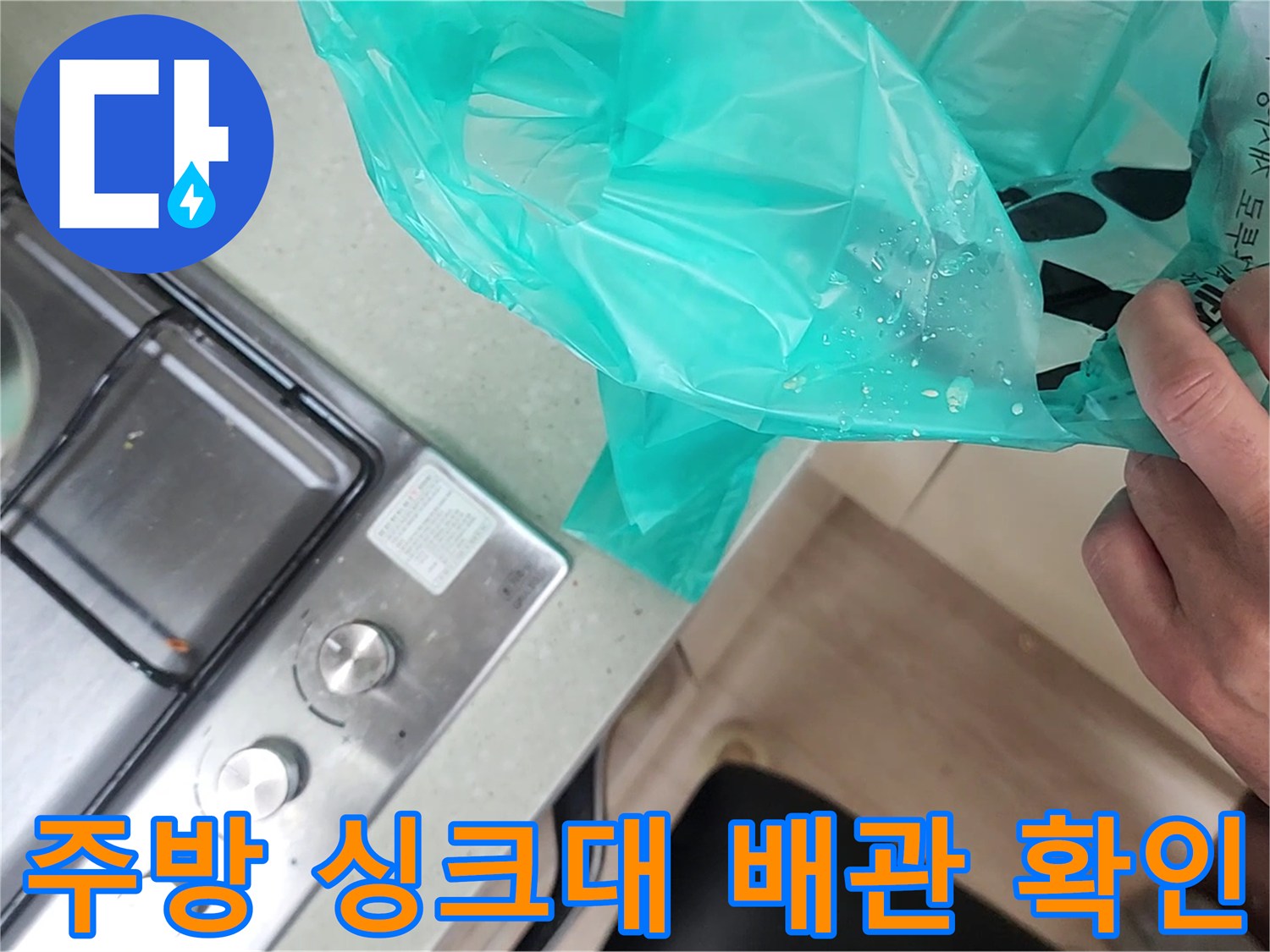 싱크대 하단 가스레인지 주변의 비닐 봉투와 배관 점검 모습