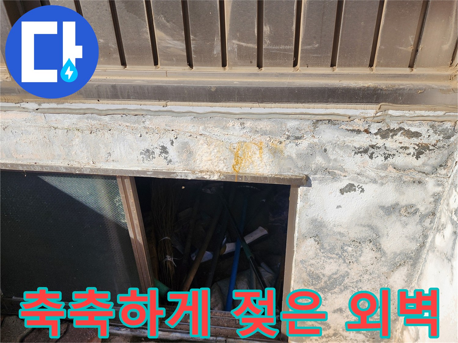 습기가 가득 차서 변색된 건물 하단부 외벽 모습