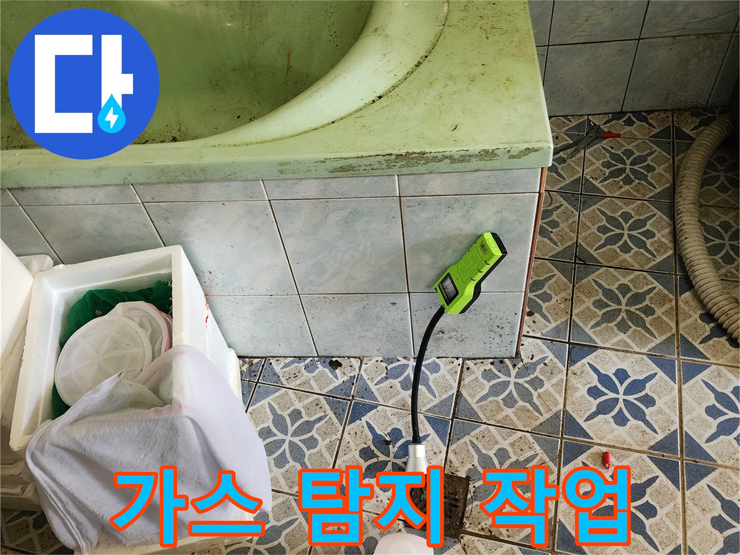 욕실 바닥 타일 위 가스 탐지 장비와 청소 도구