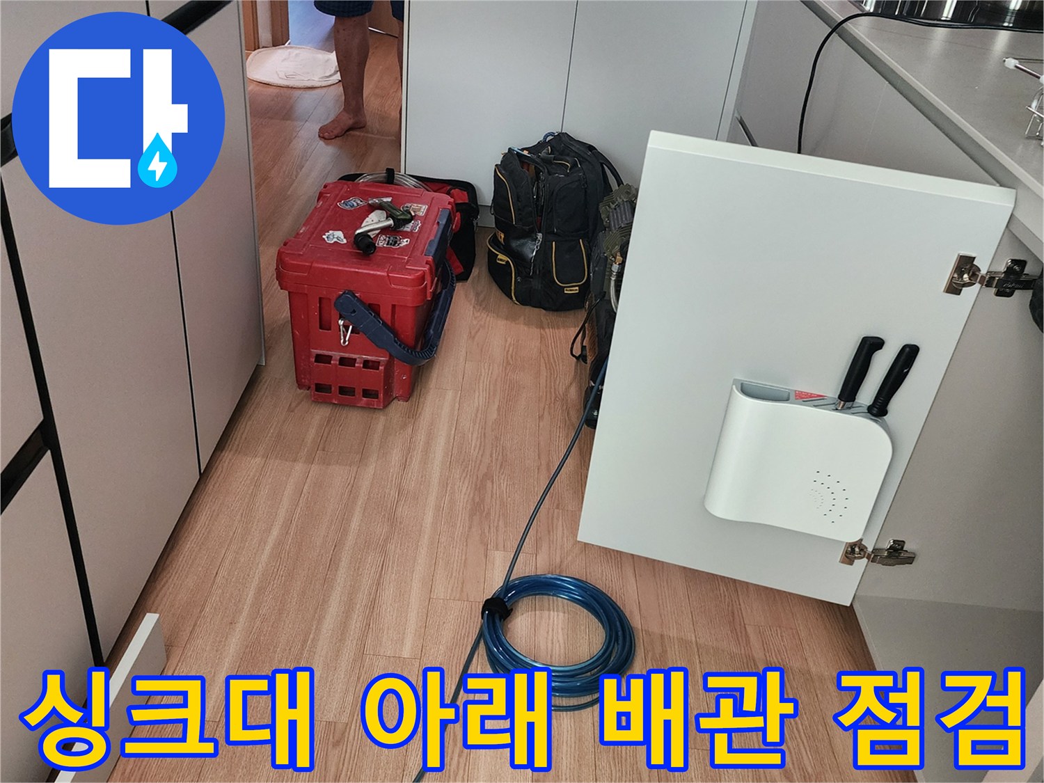 싱크대 하부장 내부와 바닥에 놓인 누수 탐지 장비 세트
