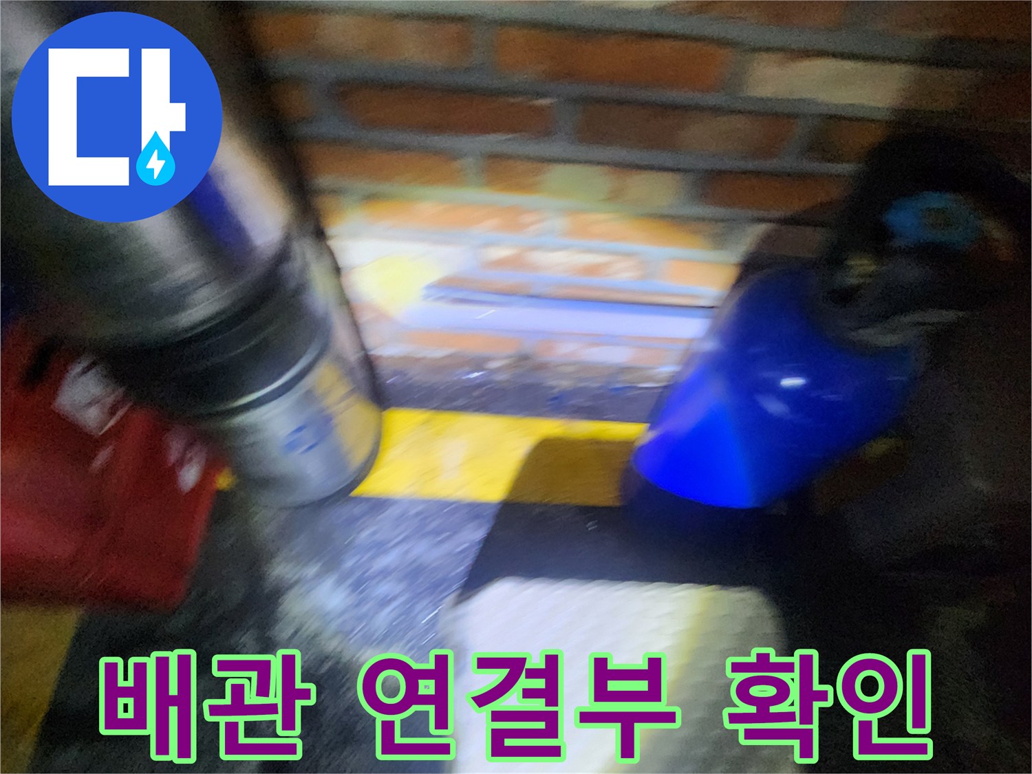 벽돌 구조물 근처의 노후된 배관 부속을 점검하고 있습니다.