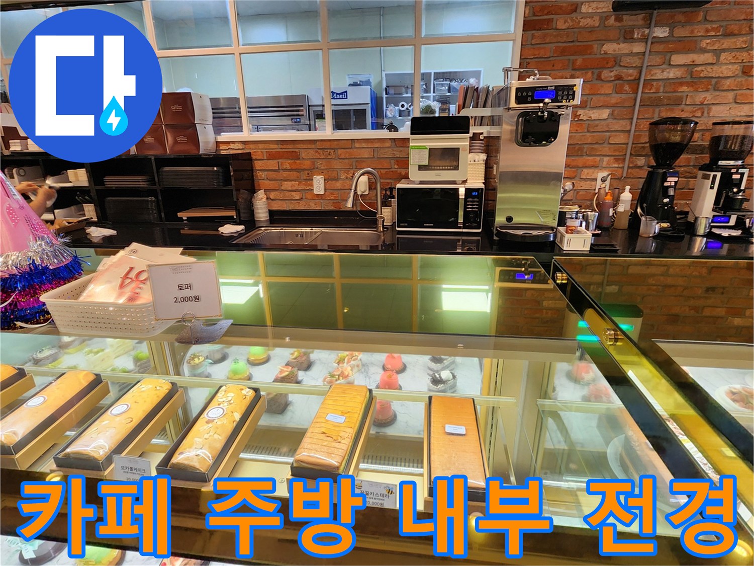 벽돌 벽면과 디저트 쇼케이스가 어우러진 카페 주방