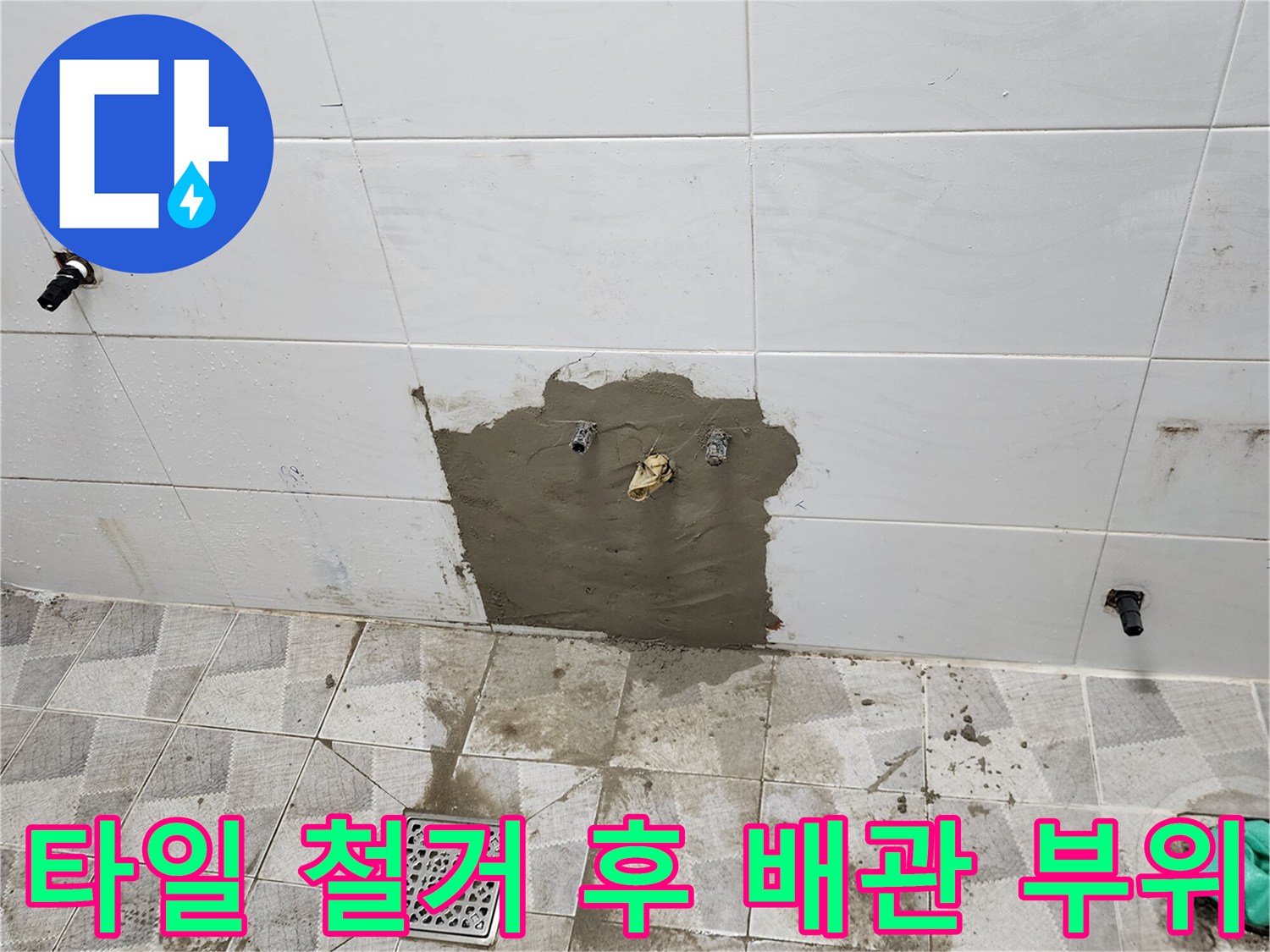 벽면 타일을 제거하고 시멘트로 채워진 배관 주변 노출 상태